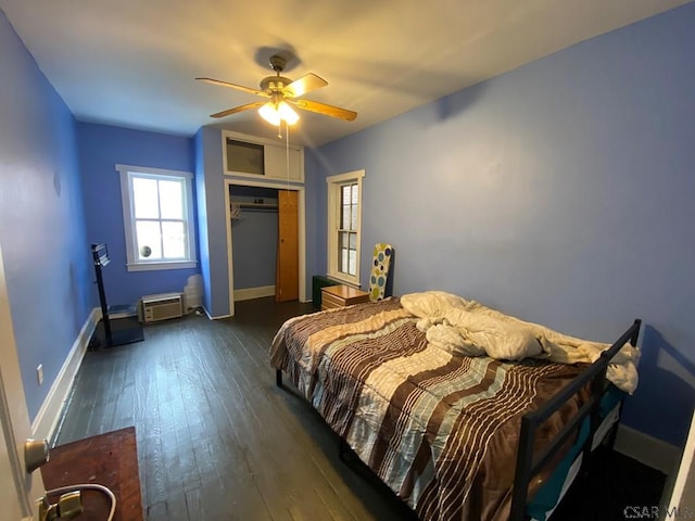 bedroom featuring ceiling fan, dark wood-style flooring, a closet, and baseboards