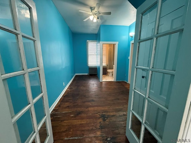 corridor with baseboards and wood finished floors