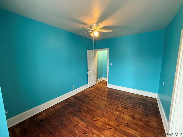 empty room featuring dark wood-style flooring, ceiling fan, and baseboards