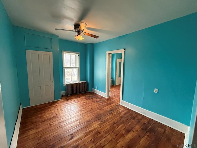 unfurnished bedroom with radiator, ceiling fan, baseboards, and dark wood-style flooring