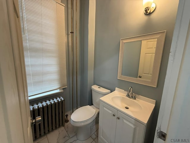 bathroom with toilet, marble finish floor, radiator heating unit, and vanity