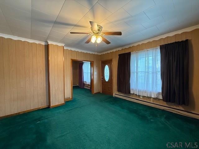 201 7th St, Windber, PA 15963 - spare room with baseboard heating, a ceiling fan, carpet flooring, crown molding, and wood walls