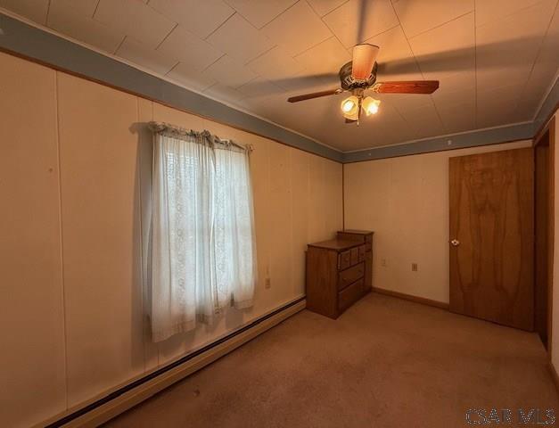 201 7th St, Windber, PA 15963 - unfurnished bedroom featuring a baseboard heating unit, light colored carpet, and ceiling fan