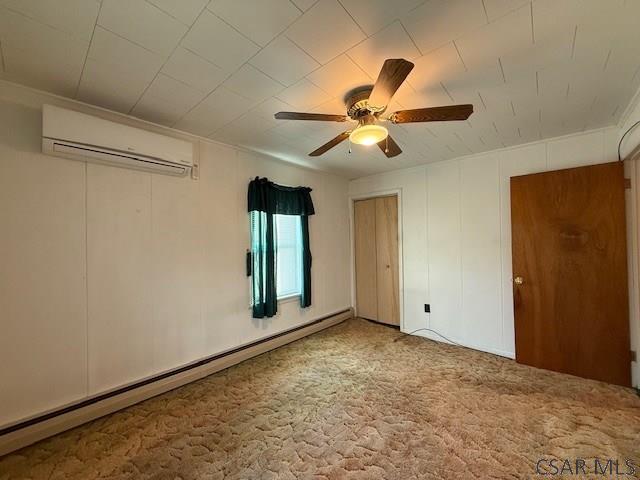 201 7th St, Windber, PA 15963 - carpeted empty room featuring an AC wall unit, baseboard heating, and a ceiling fan