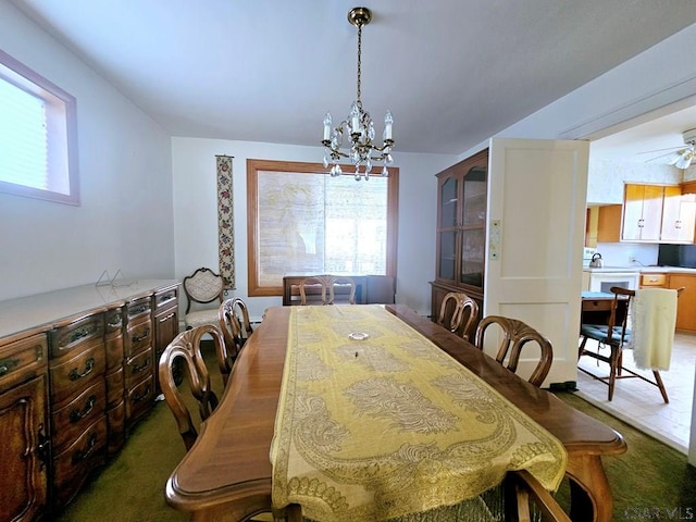 dining space featuring ceiling fan with notable chandelier