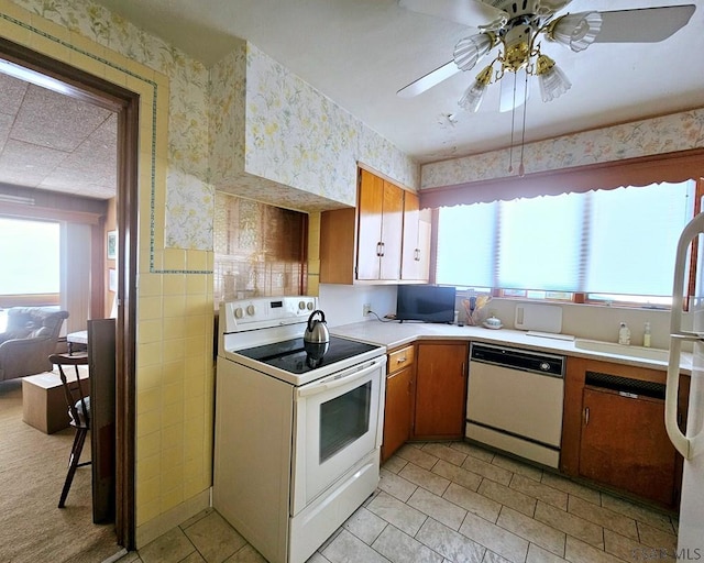 kitchen featuring white appliances, light countertops, and wallpapered walls