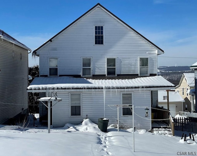 view of snow covered rear of property