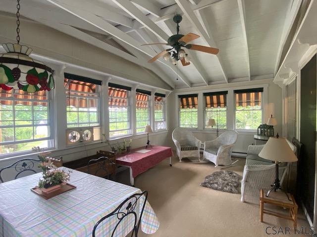 sunroom with lofted ceiling, ceiling fan, and baseboard heating