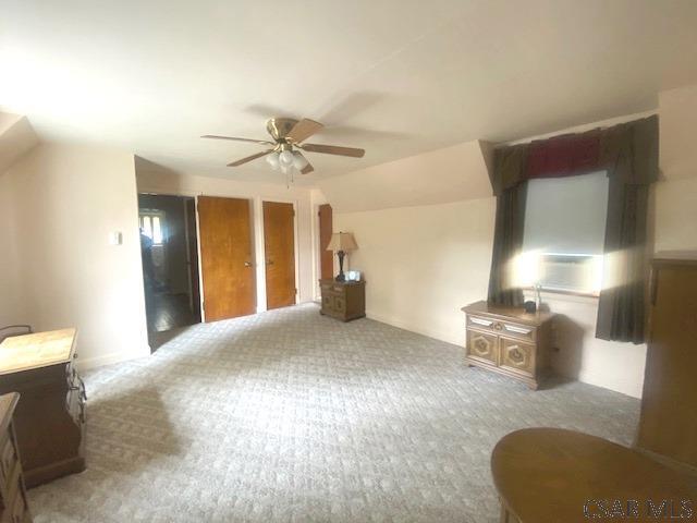 unfurnished living room featuring ceiling fan, lofted ceiling, and carpet floors