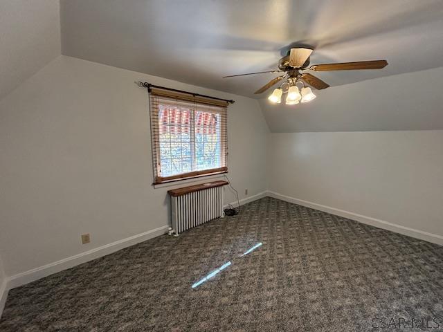 bonus room featuring vaulted ceiling, radiator, ceiling fan, and dark carpet