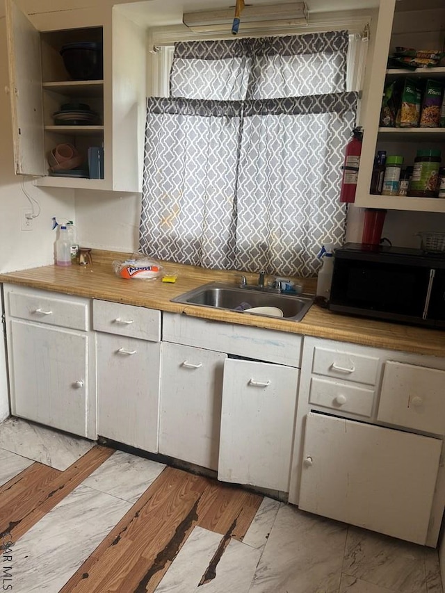 100 Cook St, Johnstown, PA 15906 - kitchen featuring black microwave, a sink, open shelves, white cabinetry, and light countertops