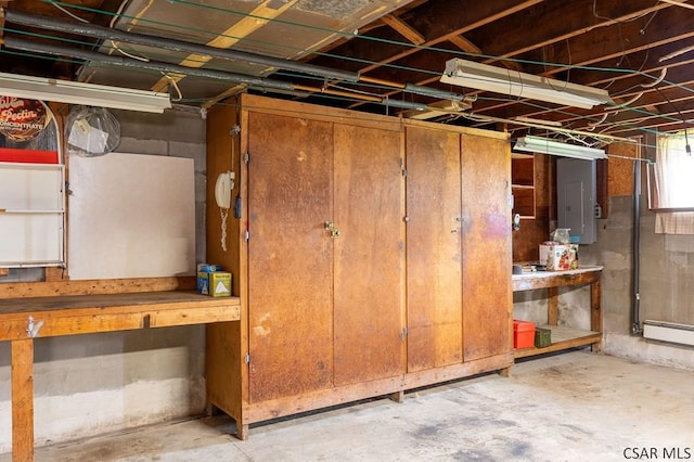 basement featuring electric panel and a baseboard heating unit