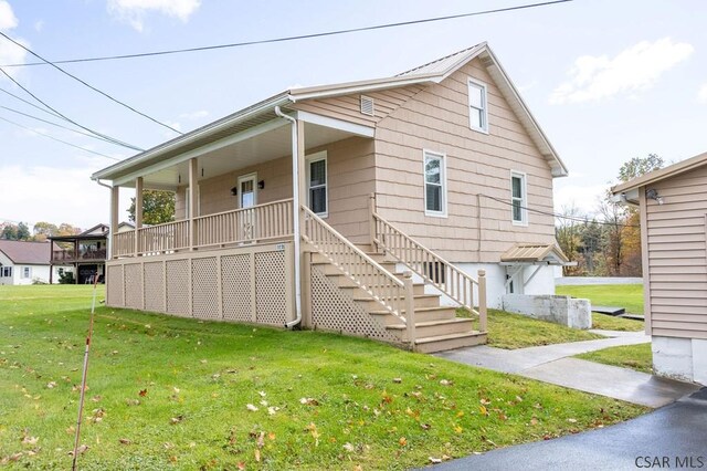 view of front of property with covered porch and a front yard