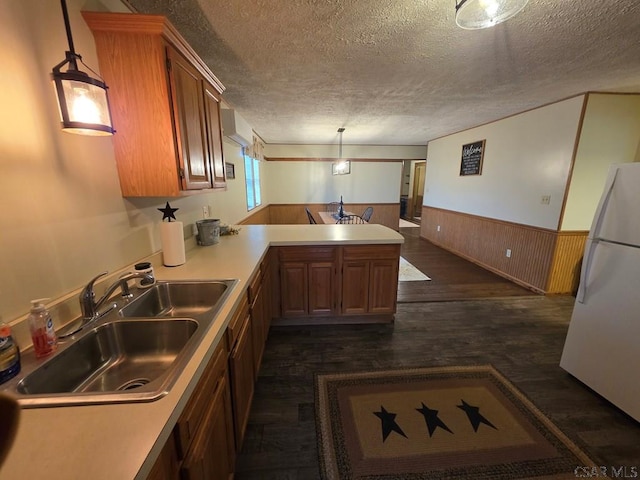 218 Center St, Meyersdale, PA 15552 - kitchen with a peninsula, a sink, freestanding refrigerator, a wainscoted wall, and a textured ceiling