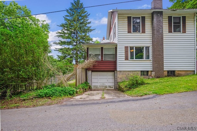 769 Russell Ave, Johnstown, PA 15902 - view of front facade with a chimney, an attached garage, and driveway