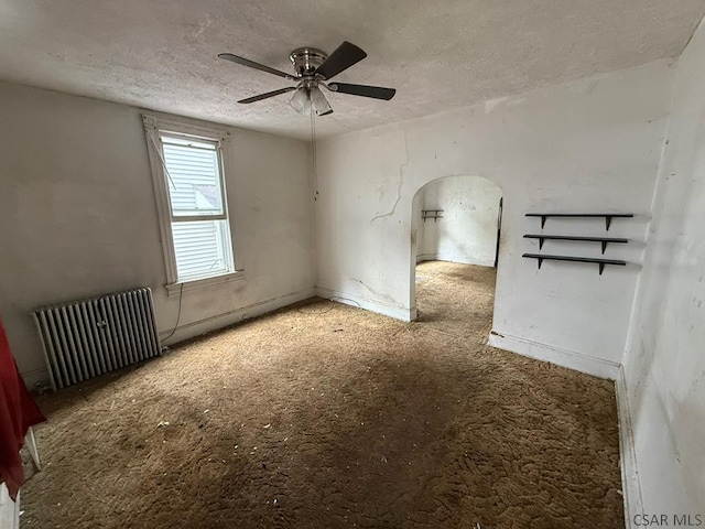 717-719 Messenger St, Johnstown, PA 15902 - empty room with radiator heating unit, arched walkways, a ceiling fan, a textured ceiling, and carpet flooring