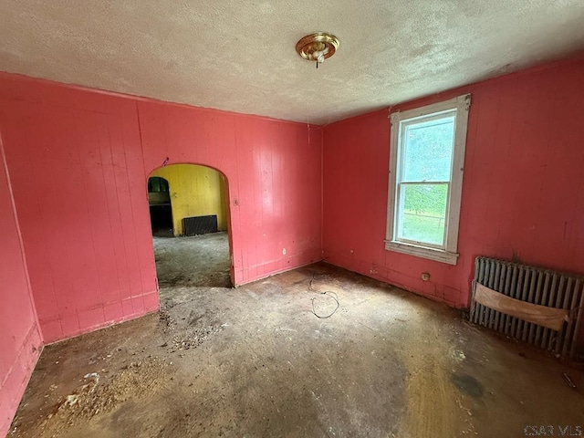 717-719 Messenger St, Johnstown, PA 15902 - spare room with a textured ceiling, arched walkways, and unfinished concrete floors