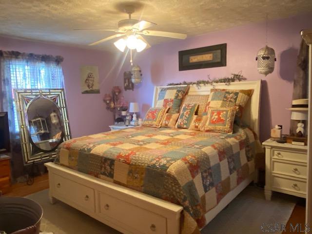 bedroom featuring a textured ceiling and ceiling fan