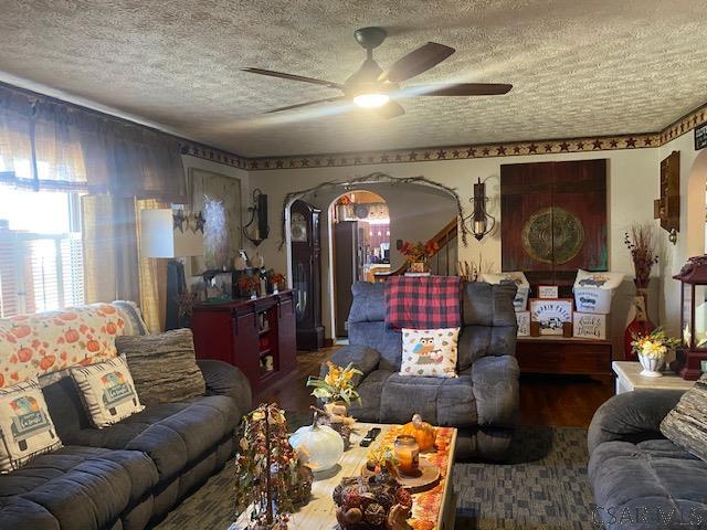 living room with ceiling fan and a textured ceiling