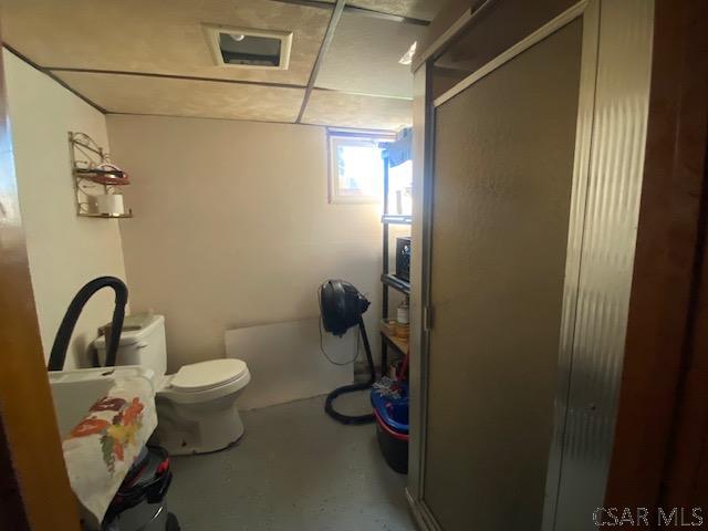 bathroom with an enclosed shower and toilet