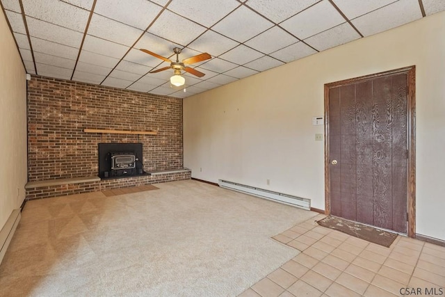 527 Patton St, Somerset, PA 15501 - unfurnished living room with a baseboard heating unit, a ceiling fan, a wood stove, a drop ceiling, and carpet floors
