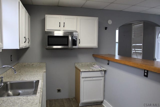 kitchen featuring white cabinetry and sink