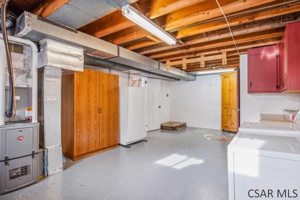 basement featuring white refrigerator and washing machine and dryer