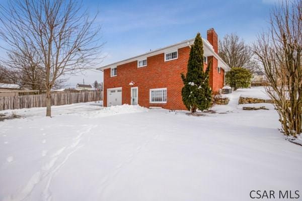 snow covered property featuring a garage