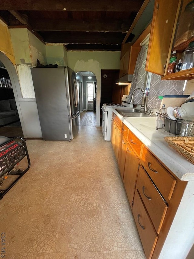 115 N St, Johnstown, PA 15906 - kitchen with a sink, arched walkways, freestanding refrigerator, light floors, and white range with gas cooktop
