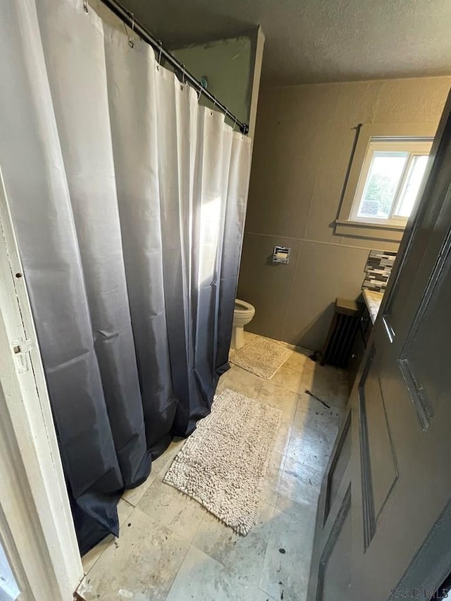115 N St, Johnstown, PA 15906 - bathroom featuring tile walls, toilet, a textured ceiling, and a shower with shower curtain