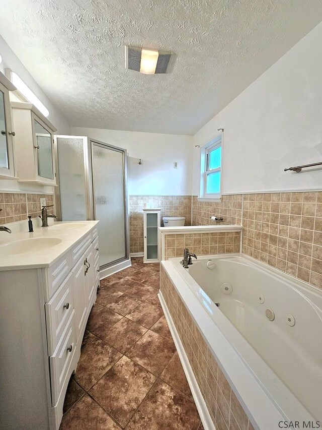 bathroom with vanity, plus walk in shower, tile patterned flooring, and a textured ceiling