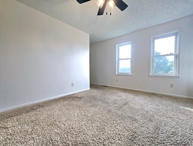 carpeted empty room featuring a textured ceiling and ceiling fan