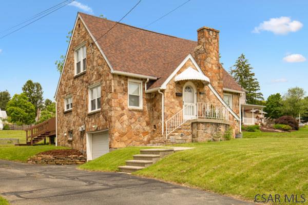 1082 W Main St, Somerset, PA 15501 - tudor house with stone siding, stairway, an attached garage, a chimney, and a front yard