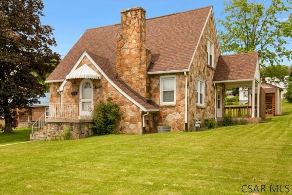 1082 W Main St, Somerset, PA 15501 - view of front facade featuring stone siding, a front lawn, a chimney, and a shingled roof