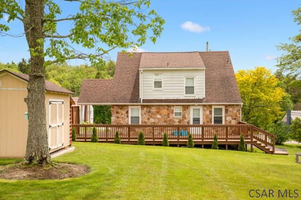 1082 W Main St, Somerset, PA 15501 - rear view of house featuring stone siding, a lawn, and a wooden deck