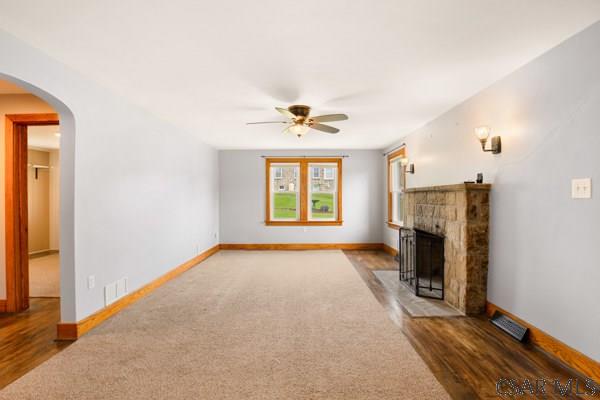 1082 W Main St, Somerset, PA 15501 - unfurnished living room with ceiling fan, a fireplace, carpet floors, arched walkways, and baseboards