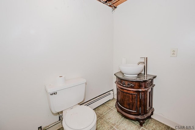 half bath featuring baseboard heating, vanity, and toilet