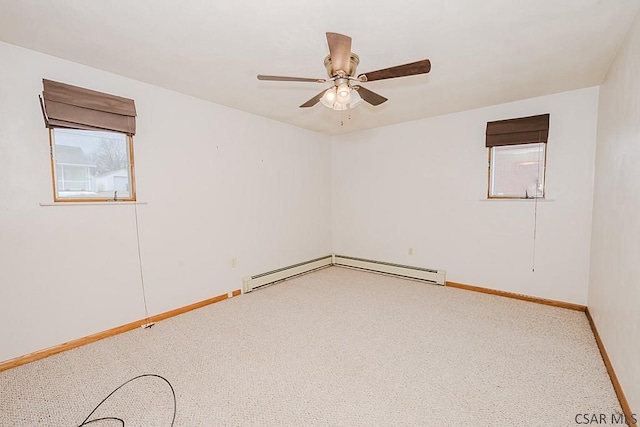 spare room featuring a ceiling fan, carpet, a baseboard heating unit, and baseboards