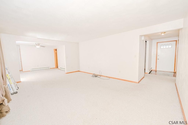 spare room with light carpet, a baseboard radiator, baseboards, and ceiling fan