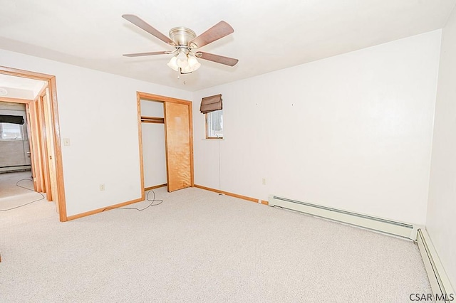 unfurnished bedroom with a baseboard radiator, baseboards, a closet, and light colored carpet