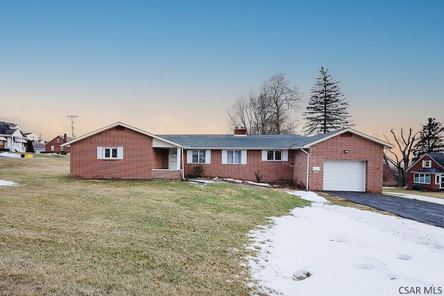 single story home with aphalt driveway, a garage, brick siding, a front lawn, and a chimney