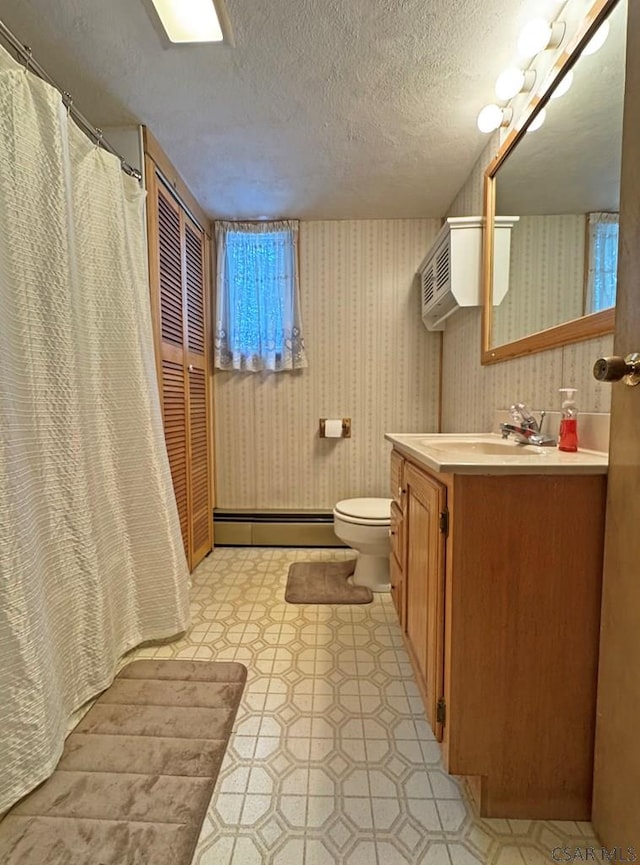 bathroom featuring a baseboard radiator, vanity, toilet, and a textured ceiling