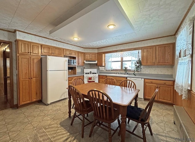 kitchen with crown molding, sink, and white appliances