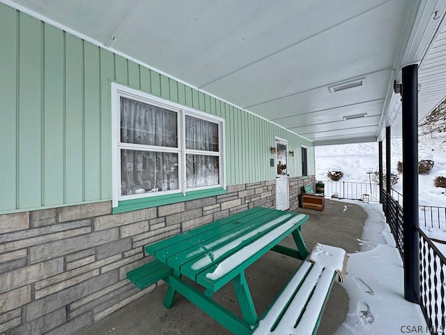 snow covered patio featuring covered porch