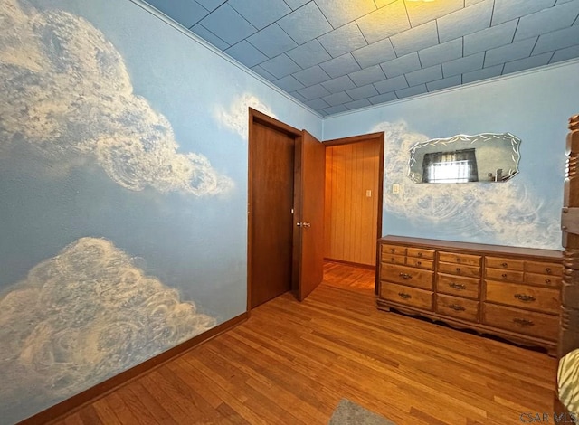 bedroom with crown molding and light wood-type flooring