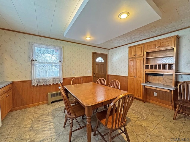 dining space with crown molding and radiator heating unit