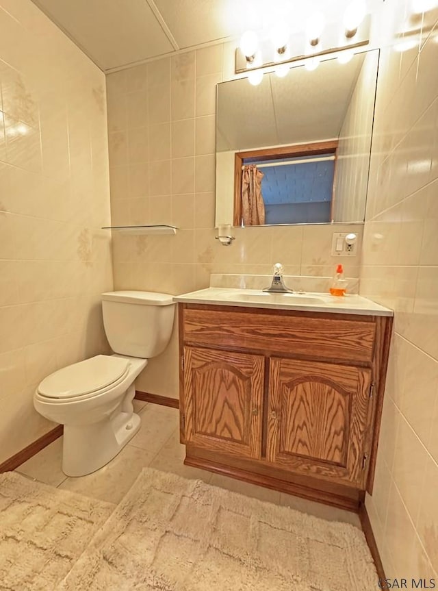 bathroom with vanity, toilet, tile walls, and decorative backsplash