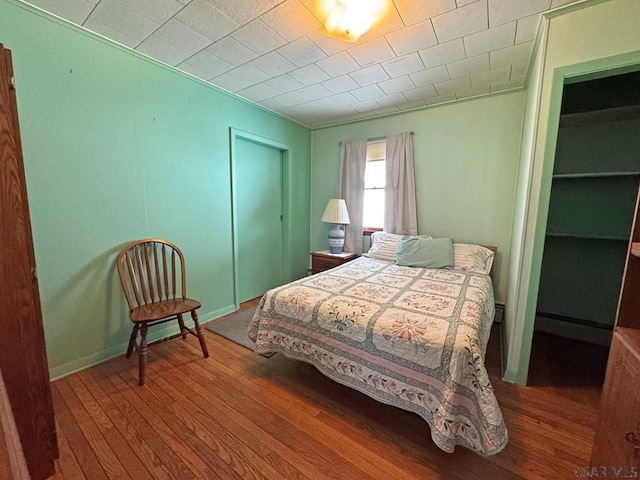 bedroom with wood-type flooring and a closet