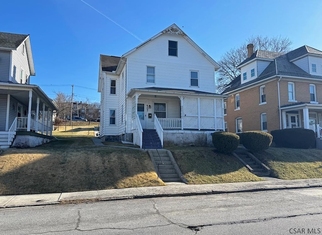 view of front of house with stairway, a porch, and a front yard