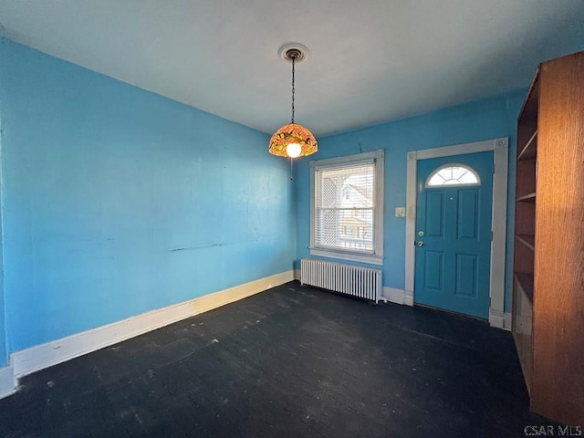 foyer entrance with radiator heating unit and baseboards